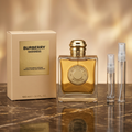 Burberry Goddess Intense bottle and box beside clear glass 5 ml and 10 ml travel sprays in a warm gold marble setting