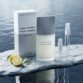 Issey Miyake bottle and box with clear-glass travel sprays in an atmospheric aquatic setting